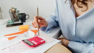 A woman calculating taxes using a calculator.