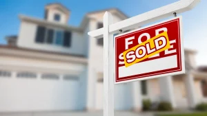 A 'For Sale – Sold' sign in front of a residential property with a blue sky background, representing investment real estate transactions and 1031 exchange planning in Arizona.